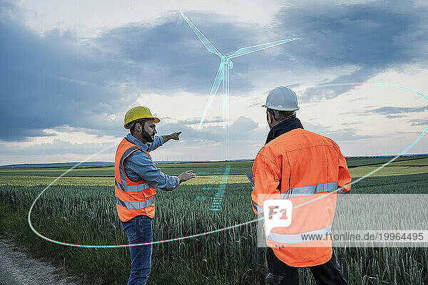 Engineers planning over digital wind turbine model in field