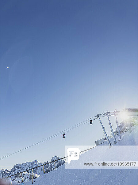 Austria  Tyrol  Axamer Lizum  Clear sky over overhead cable cars hanging over snowcapped peak in European Alps