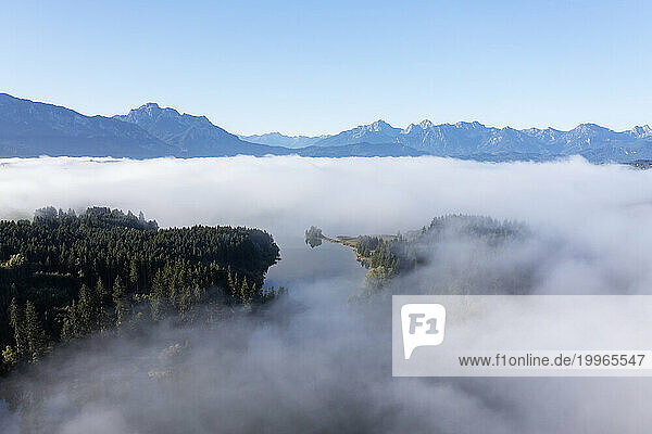 Germany  Bavaria  Aerial view of Illasbergsee and Forggensee lakes shrouded in thick fog
