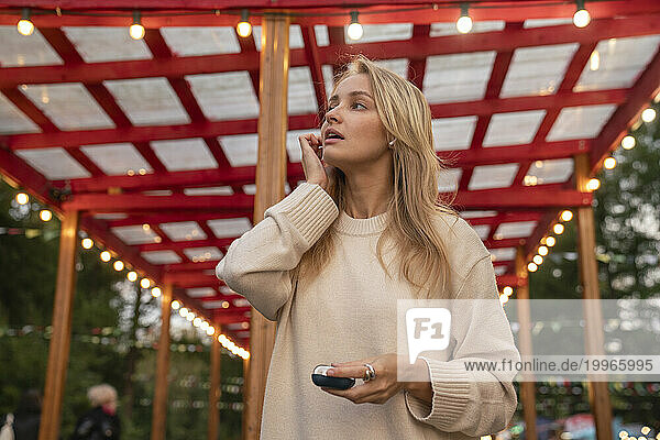 Woman wearing wireless in-ear headphones at amusement Park