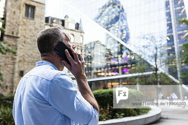 Businessman talking on smart phone at office park