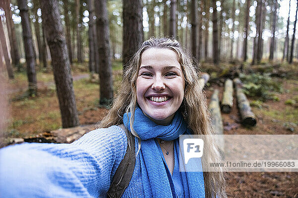 Happy beautiful woman taking selfie in Cannock chase forest
