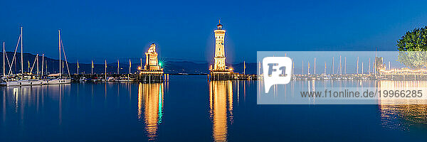 Germany  Bavaria  Lindau  Harbor of town on shore of lake Bodensee at night with lighthouse and Bavarian Lion sculpture in background