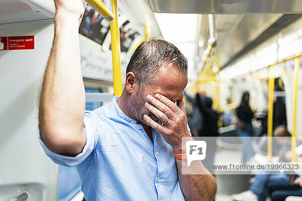 Tired businessman commuting through train