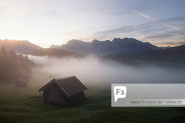 Germany  Bavaria  Alpine hut at foggy sunrise