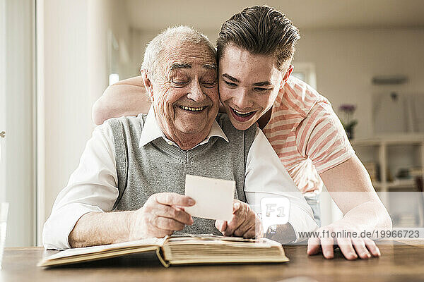 Happy grandfather and grandson looking at photographs together