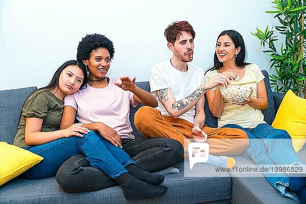 Verschiedene Freunde  die zusammen auf dem Sofa in einer Wohnung sitzen und einen Film ansehen