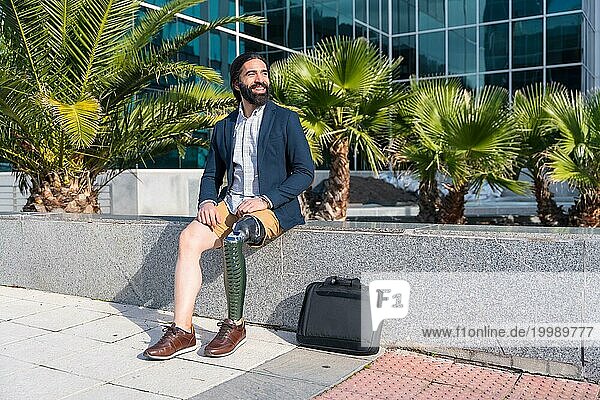 Geschäftsmann mit Beinprothese vor einem Finanzgebäude an einem sonnigen Tag in der Stadt