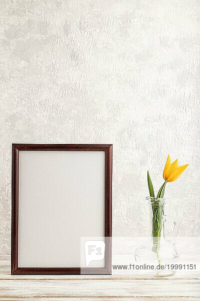 Holzrahmen mit orangefarbenen Tulpe Blume im Glas auf grauem Beton Hintergrund. Seitenansicht  Kopie Raum  Stillleben  Mockup  Vorlage  Frühling  Sommer Minimalismus Konzept