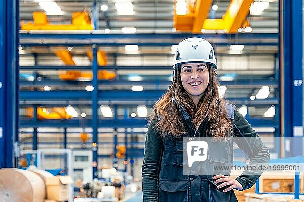 Porträt einer lächelnden Arbeiterin mit Schutzkleidung in einem Logistikzentrum