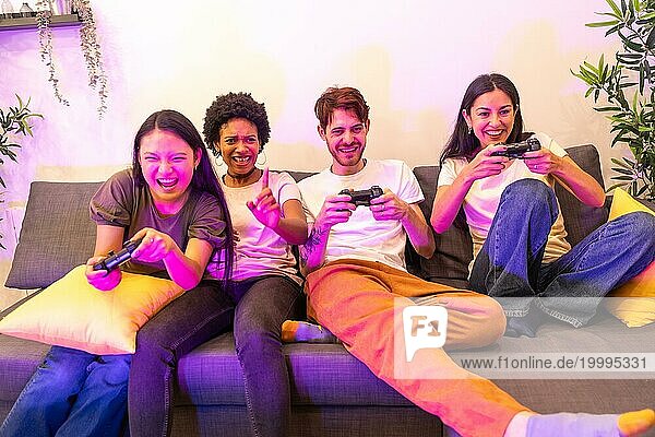 Multiethnische Freunde haben Spaß beim gemeinsamen Konsolenspiel auf der Couch zu Hause