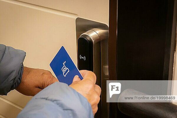 Ausgeschnittene Ansicht einer Touristin  die eine Schlüsselkarte benutzt  um eine elektronische Tür in einem Luxushotel zu entriegeln