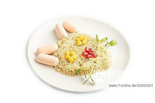 Lustige gemischte Quinoa Brei  Mais  Granatapfelkerne und kleine Würstchen in Form von Katzengesicht vor weißem Hintergrund. Seitenansicht  Nahaufnahme. Lebensmittel für Kinder  gesundes Essen Konzept