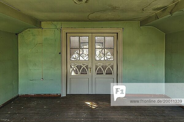 Verlassenes Zimmer mit abblätternder grüner Wandfarbe und einfachen weißen Türen  Schachtrupp-Villa  Lost Place  Osterode am Harz  Niedersachsen  Deutschland  Europa