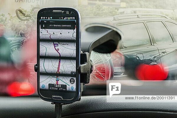 Smartphone mit Navigations  App an der Frontscheibe eines PKW
