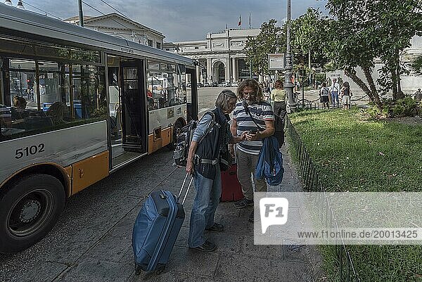 Tourists with Iphones at a bus stop  railway station in Genoa  Italy  Europe