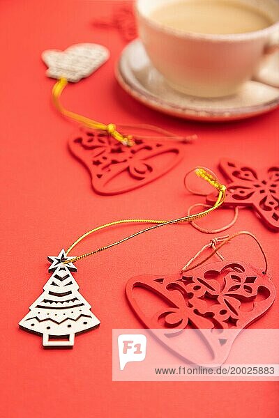 Weihnachten oder Neujahr Zusammensetzung. Dekorationen  Tanne und Fichte Zweige  Tasse Kaffee  auf einem roten Papier Hintergrund. Seitenansicht  selektiver Fokus  Nahaufnahme