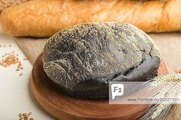 Verschiedene Arten von frisch gebackenem Brot auf einem weißen hölzernen Hintergrund. Seitenansicht  Nahaufnahme  selektiver Fokus