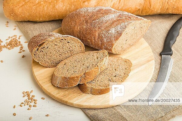 Aufgeschnittenes Brot mit verschiedenen Arten von frisch gebackenem Brot auf weißem Holzhintergrund. Seitenansicht  Nahaufnahme  selektiver Fokus