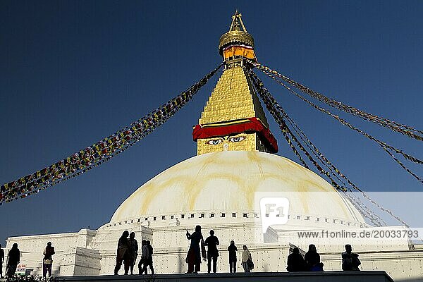 An einem sonnigen Frühlingsnachmittag versammelten sich die Menschen in Bouddhanath  der Bouddha Stupa. Sie ist die größte Stupa Nepals  eine der Weltkulturerbestätten im Kathmandutal und ein sehr wichtiges religiöses Zentrum für die Einheimischen  tibetische Flüchtlinge und alle Buddhisten. Bouddhanath wurde nach den schweren Schäden des Erdbebens von 2015 wiederaufgebaut. Großstadt Kathmandu  Bagmati Provinz  Nepal  Asien