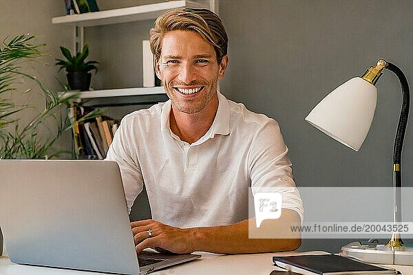 K generiert  Erfolgreicher Jungunternehmer sitzt zufrieden im Büro  30  35  Jahre  Mann  lächelt zufrieden  Existenzgründer  Firmenchef  trinkt Kaffee