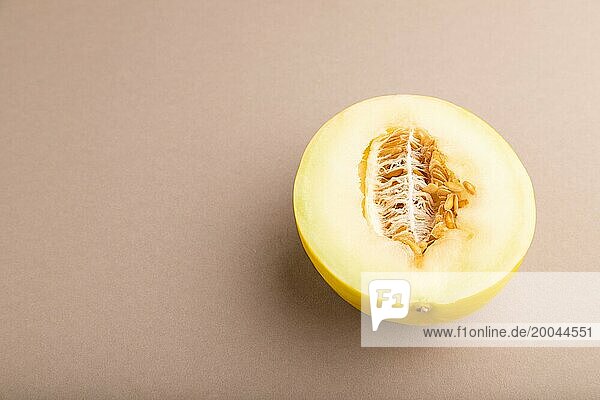 In Scheiben geschnittene reife gelbe Melone auf braunem pastellfarbenem Hintergrund. Seitenansicht  Kopie Raum. Ernte  Frauen Gesundheit  vegane Ernährung  Konzept  Minimalismus