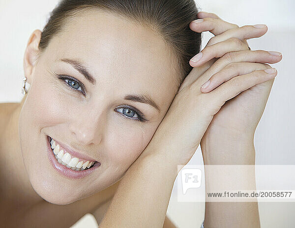 Close up Portrait of Smiling Woman with Head Leaning on Hands