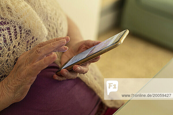 Close up hands of senior woman using smart phone