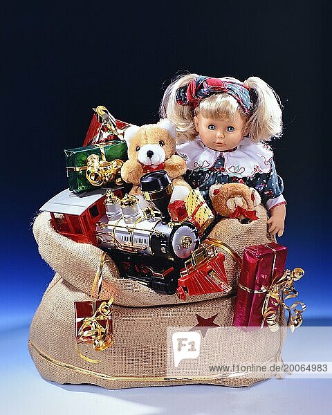 Weihnachtsgeschenke  Studioaufnahme  Geschenke im Sack  Weihnachtsmann  Nüsse  Früchte  Teddybär  Puppe  Eisenbahn