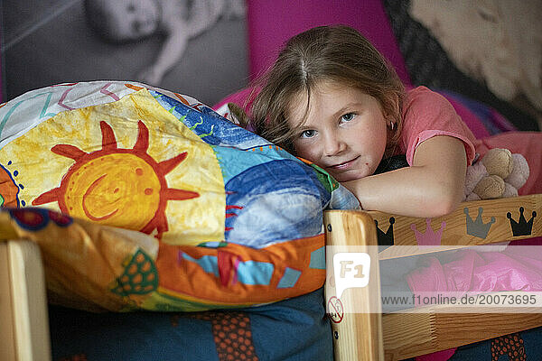 young girl laying on her bed