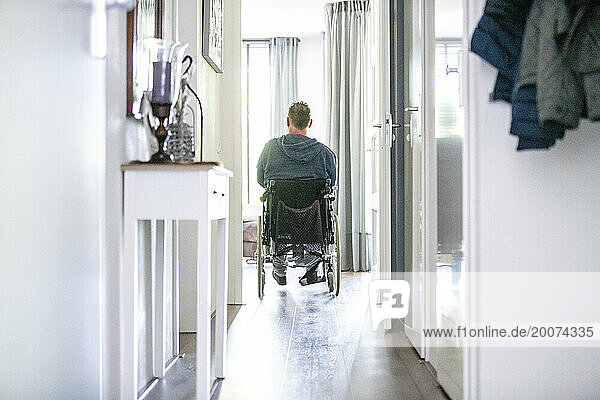 Man in wheelchair leaving the house to go to the shops