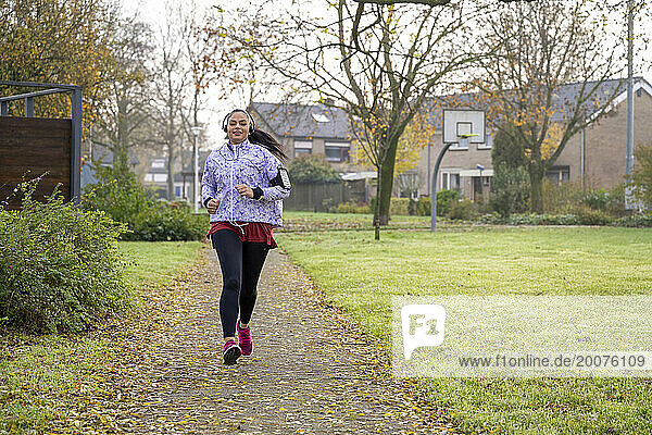Healthy woman jogging listening to music at the public park