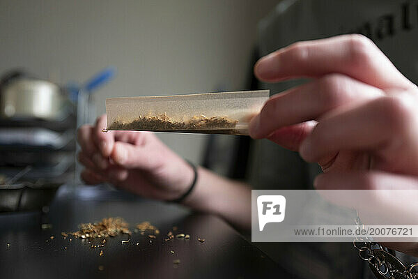 Young woman making a marijuana cigarette for health reasons