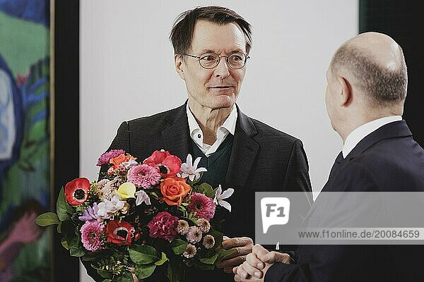 (L-R) Karl Lauterbach (SPD)  Bundesminister für Gesundheit  und Olaf Scholz (SPD)  Bundeskanzler  aufgenommen im Rahmen der wöchentlichen Sitzung des Kabinetts in Berlin  21.02.2024. Lauterbach bekommt die Blumen vom Bundeskanzler zu seinem Geburtstag überreicht
