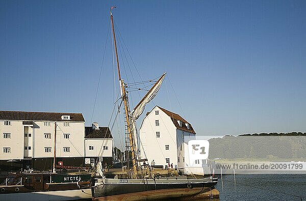 Historischer Segelkahn und weiß getünchte Gebäude der Tide Mill auf dem Fluss Deben  Woodbridge  Suffolk  England  UK