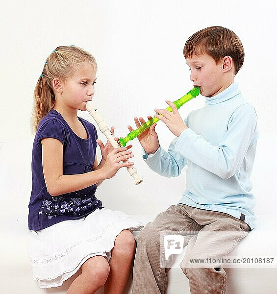 Niedliche Kinder spielen zusammen Flöte