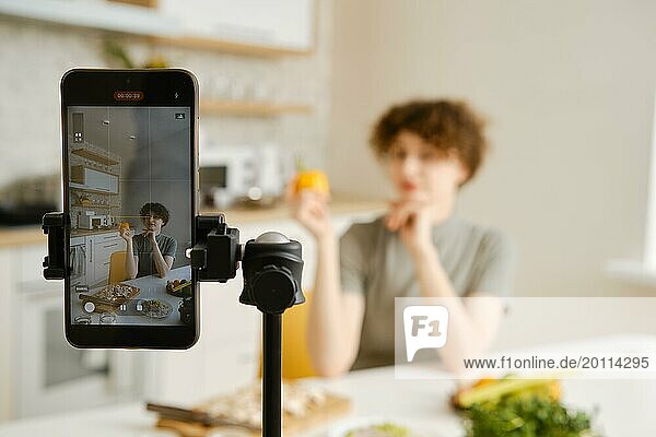 Professionelle Ernährungsberaterin filmt mit ihrem Smartphone ein Tutorial über gesunde Ernährung in ihrer Küche