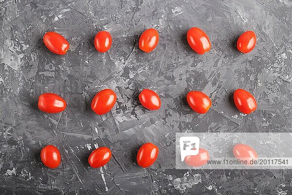 Rows of cherry tomatoes on a black concrete background  top view  flat lay