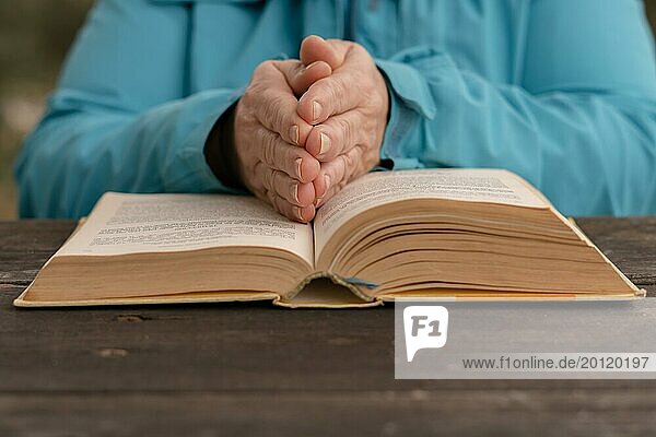 Frau mit ihren Händen auf einem heiligen Buch in Gebetshaltung