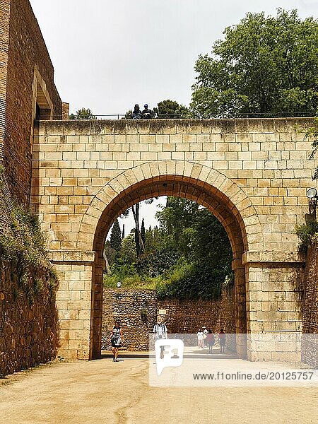 Tourists  walkers go through large gate  old town of Granada  Andalusia  Spain  Europe