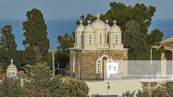 Frontal view of a church with white domes and a bell tower against a blue sky  Koroni  Byzantine fortress  nunnery  Peloponnese  Greece  Europe
