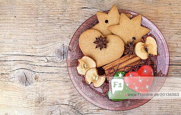 Lebkuchen und Weihnachtsdekoration auf Teller mit Gewürzen