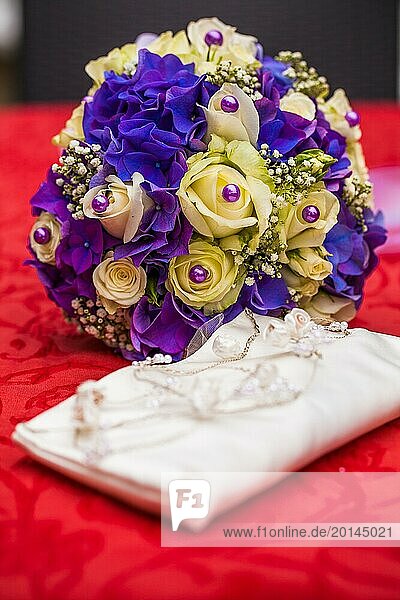 Purple bridal bouquet and white clutch