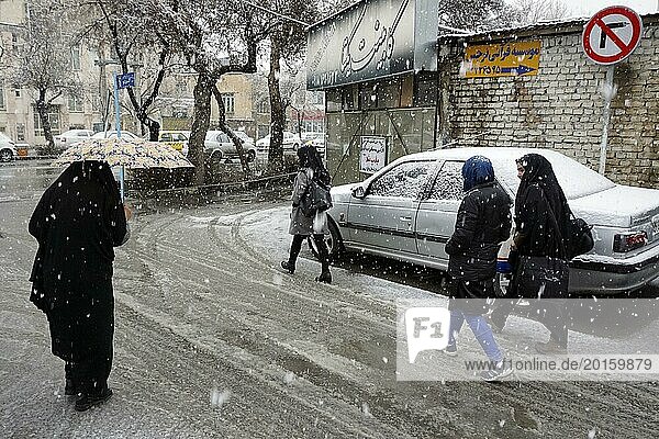 Heavy snowfall in Arak  Iran  woman with chador and umbrella and traditional clothing  16/03/2019  Asia