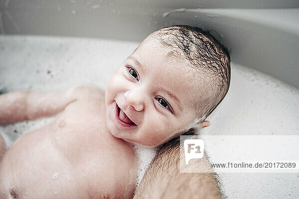 Father bathing cute baby girl at home