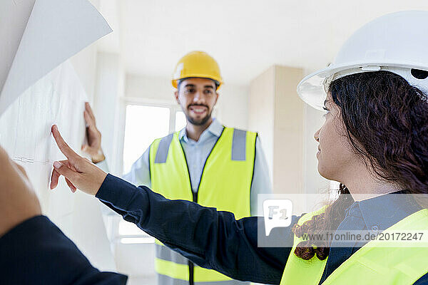 Architects discussing over blueprint at construction site