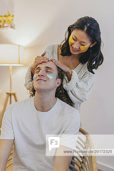 Girlfriend massaging boyfriends head at home