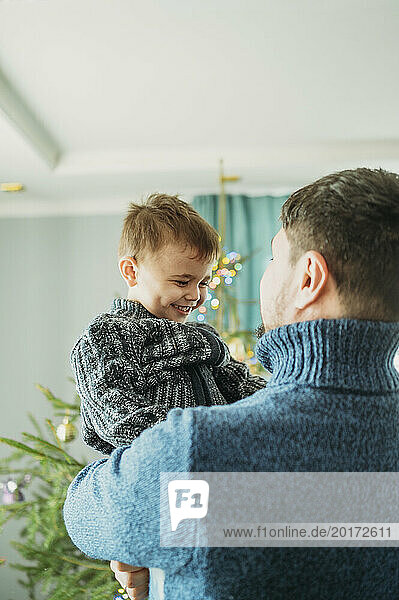 Cheerful boy having fun with father at home