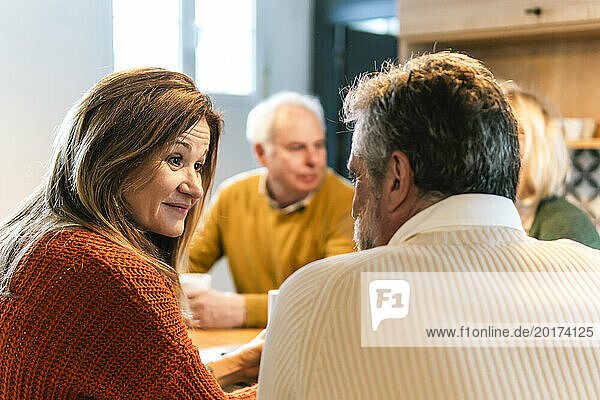 Smiling woman talking to friend at retirement party