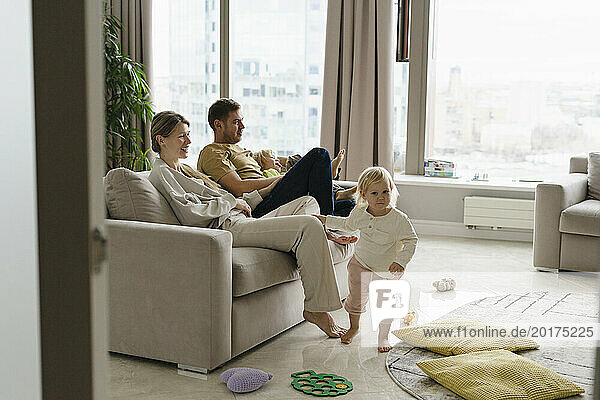 Happy family sitting on sofa and having fun at home